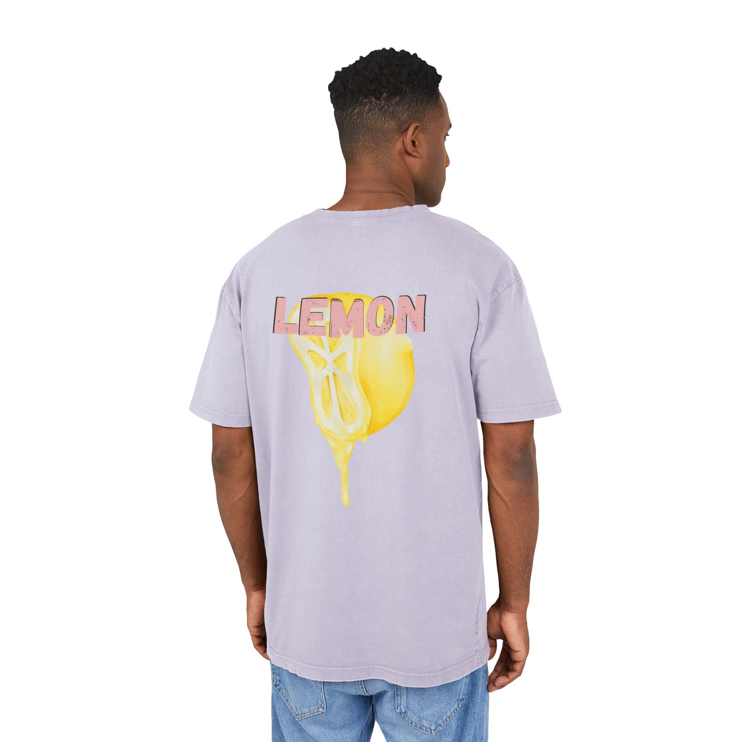 Junger Mann trägt oversized T-Shirt mit Vintage-Waschung in Flieder. Auf dem Rücken: gelber Zitronen-Print mit Schriftzug „LEMON“. 100 % Baumwolle.
